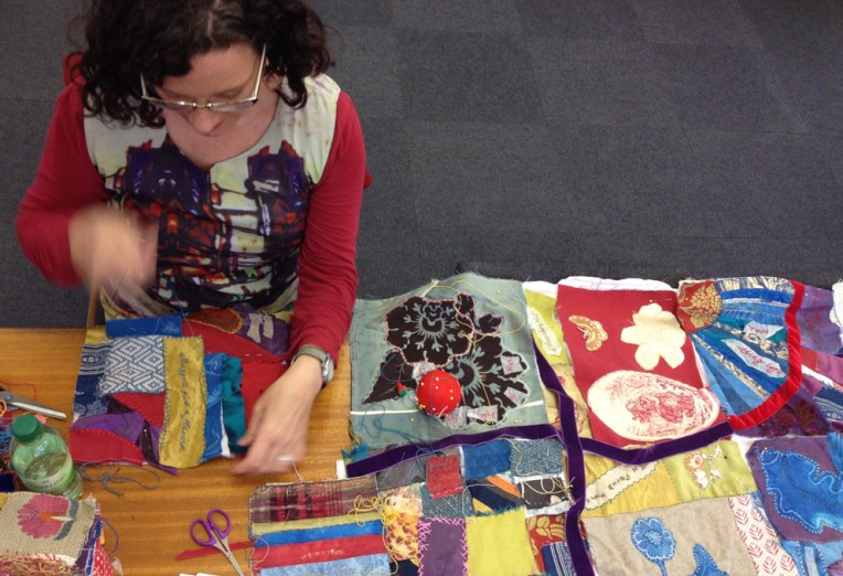 Artist Lois Blackburn working on Stitching the Wars quilt. Group quilt, Crazy quilt technique with stitched reminiscence