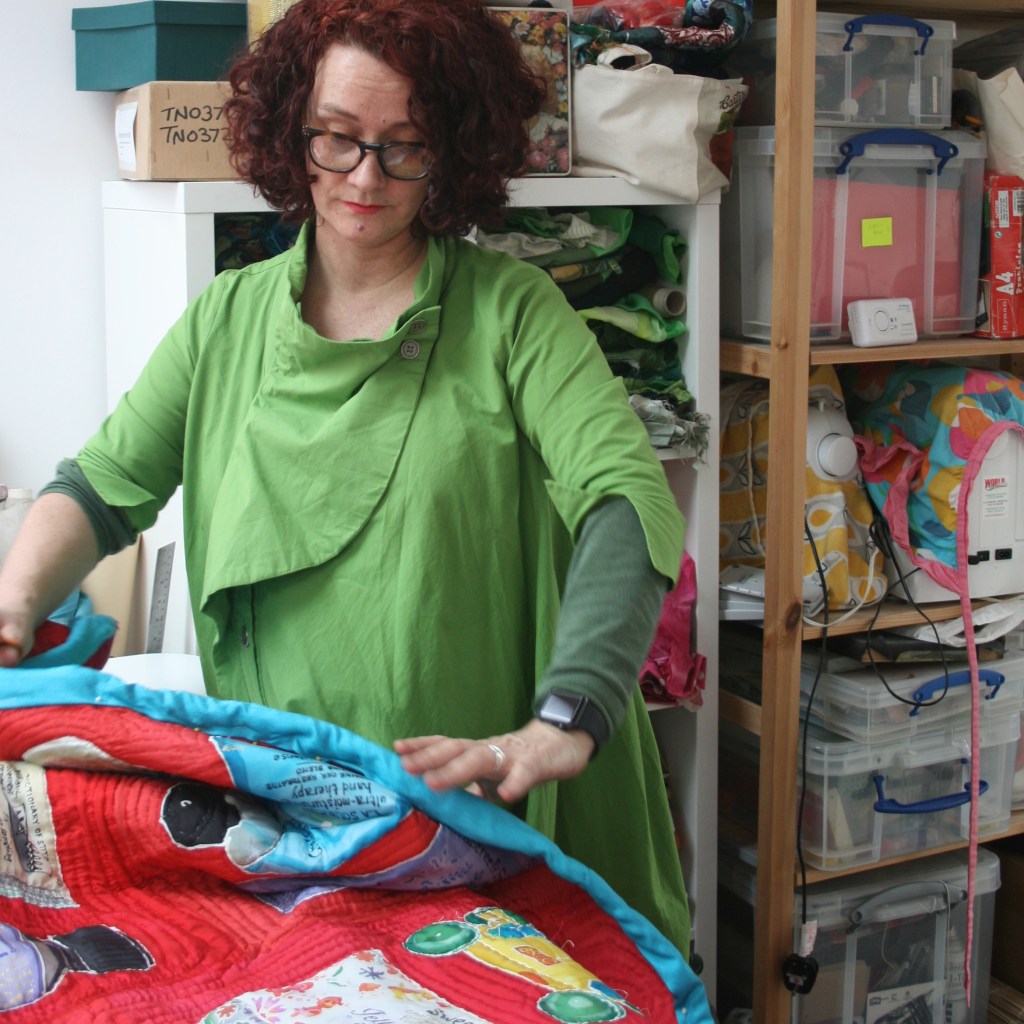 Artist Lois Blackburn working in her studio on her quilt artwork, Blood, Sweat and Tears, the Menopause Quilt. 