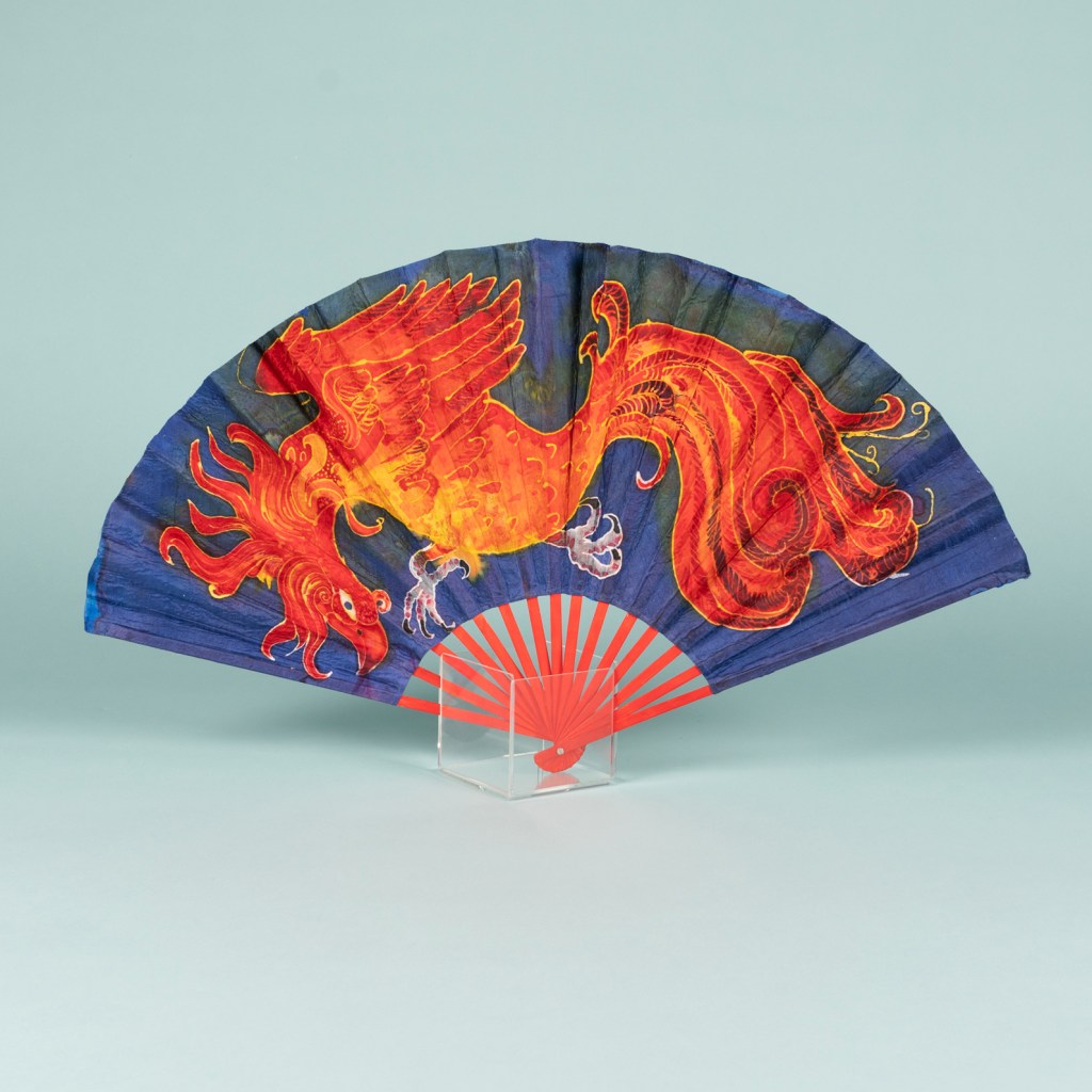 Large handmade hand fan, made of silk, illustrating a phoenix. Using batik technique.