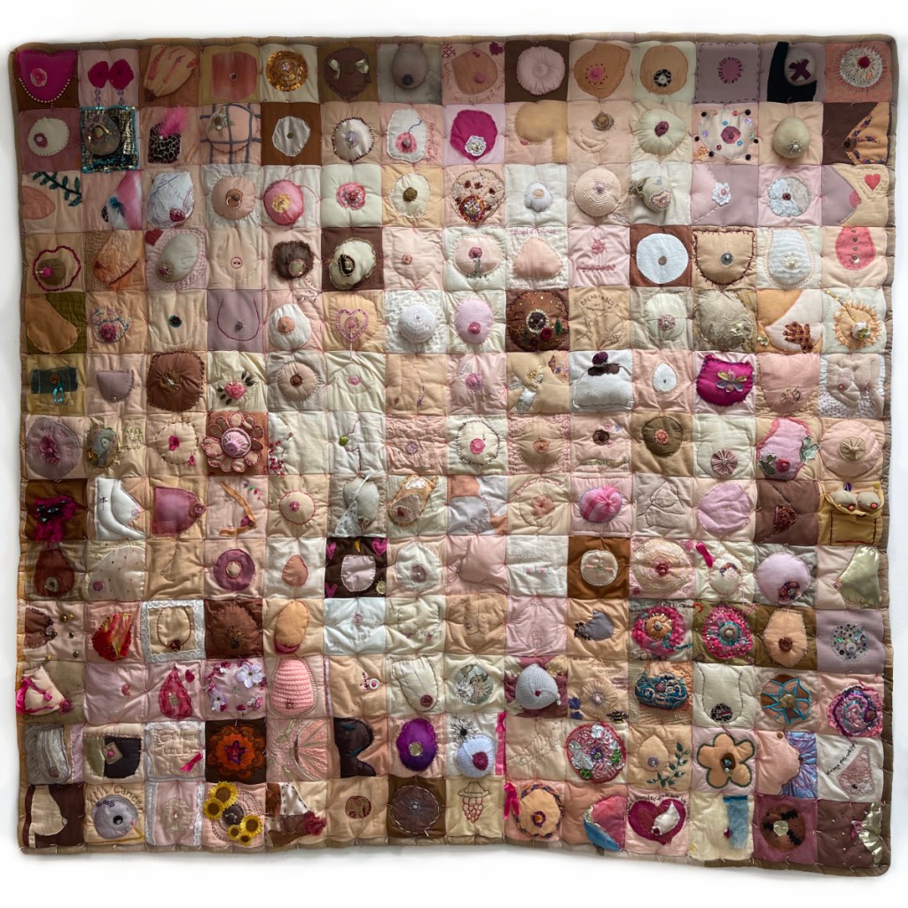 Comfort the Breast quilt. A collaborative quilt made up of over 100 embroidered breasts, all shapes and colours.