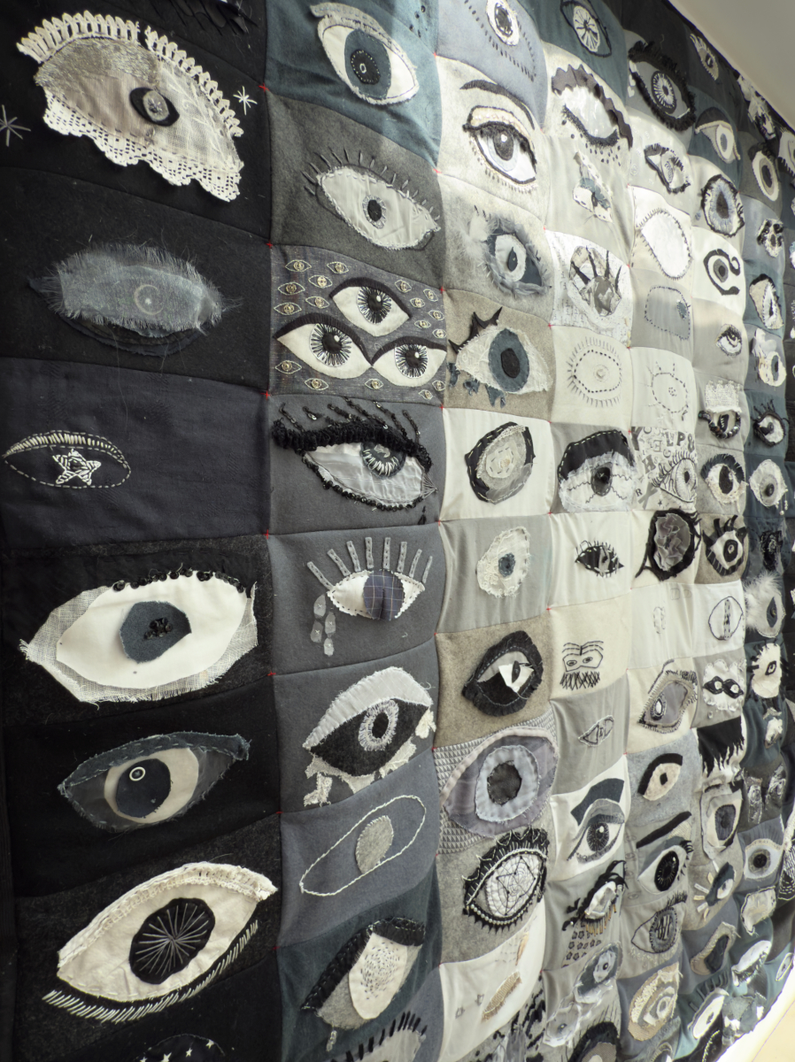 A collection of over 100 embroidered eyes. In black and white fabric, using appliqué, hand and machine stitch.
