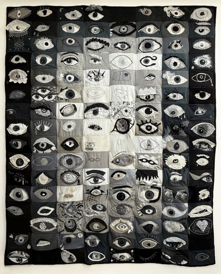 A collection of over 100 embroidered eyes. In black and white fabric, using appliqué, hand and machine stitch.