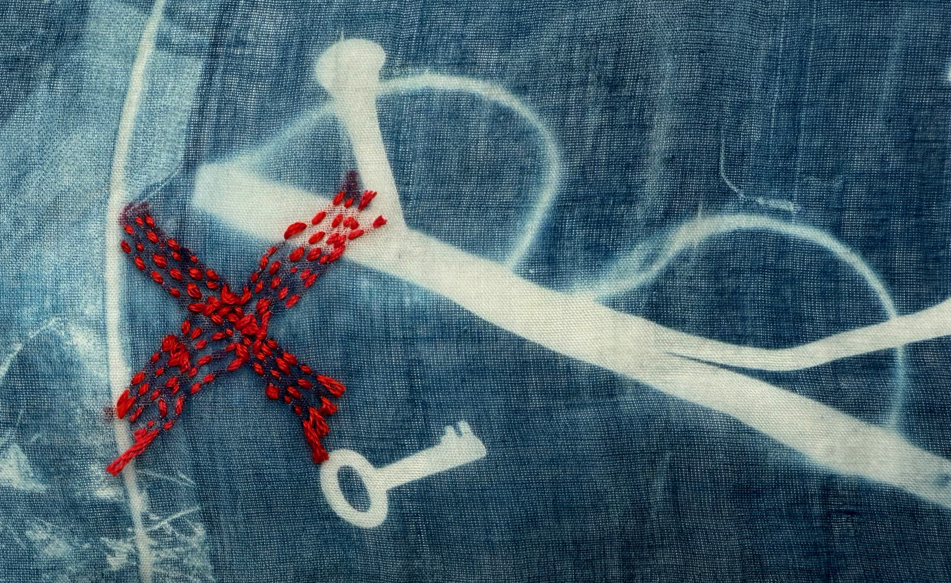Embroidered cyanotype on fabric sample. Part of Lost then Found series by Lois Blackburn. Picturing glasses, glove and keys