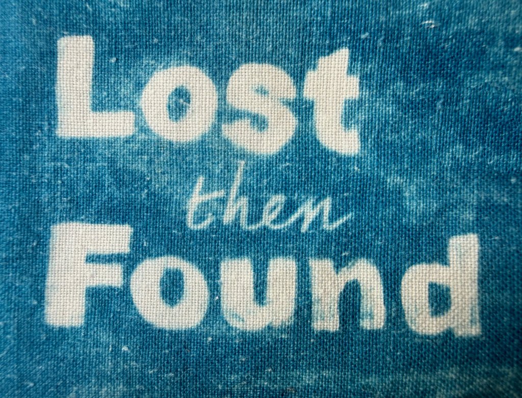 Lost the Found written onto fabric, white lettering on blue background. using cyanotype process.